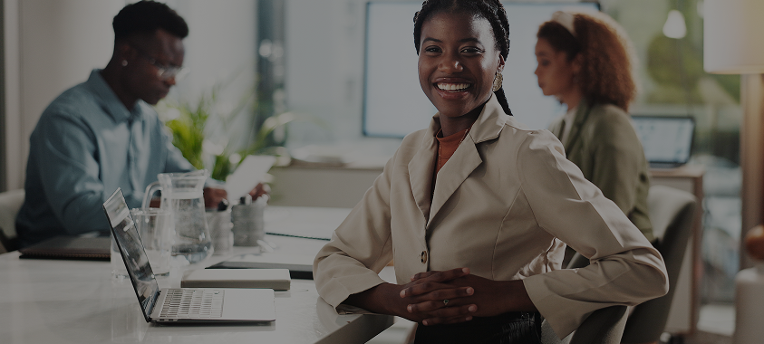 Four Sudatel employees standing together and smiling in the office